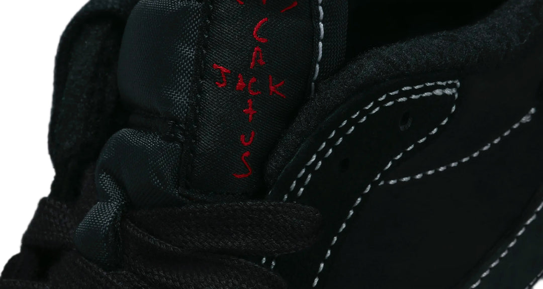 Jordan 1 Low Travis Scott Phantom en color negro con Swoosh invertido y costuras blancas