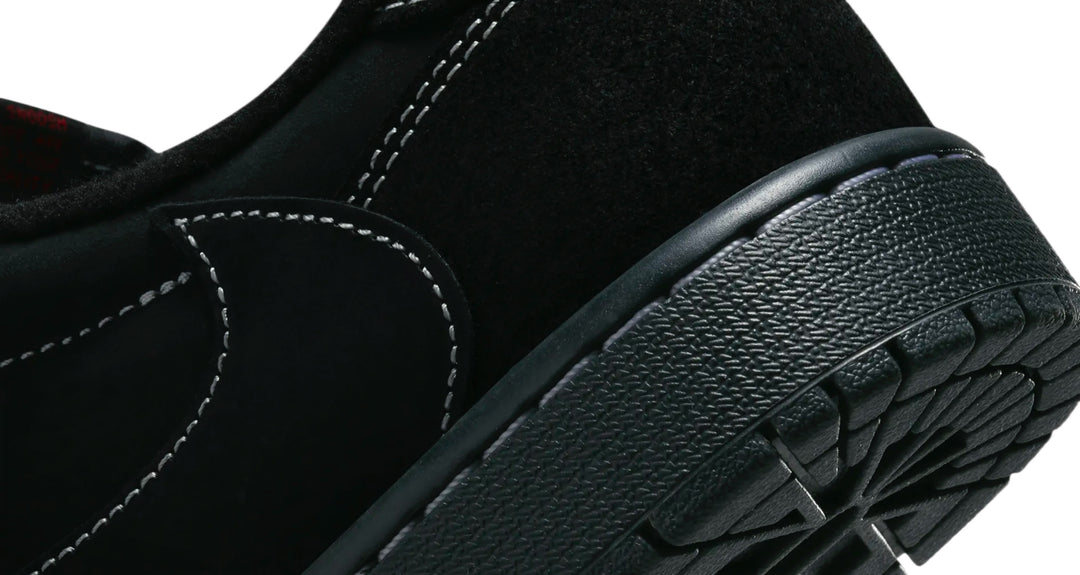 Jordan 1 Low Travis Scott Phantom en color negro con Swoosh invertido y costuras blancas
